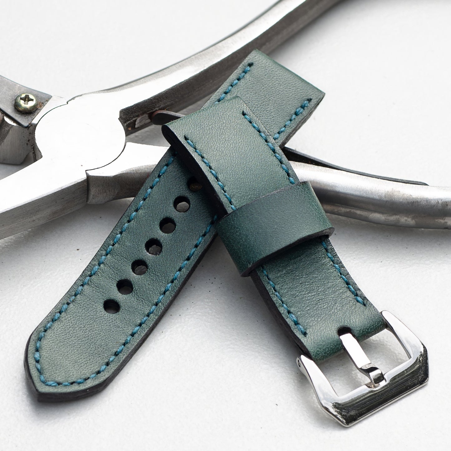 Aqua leather watch strap with teal stitching and polished steel buckle
