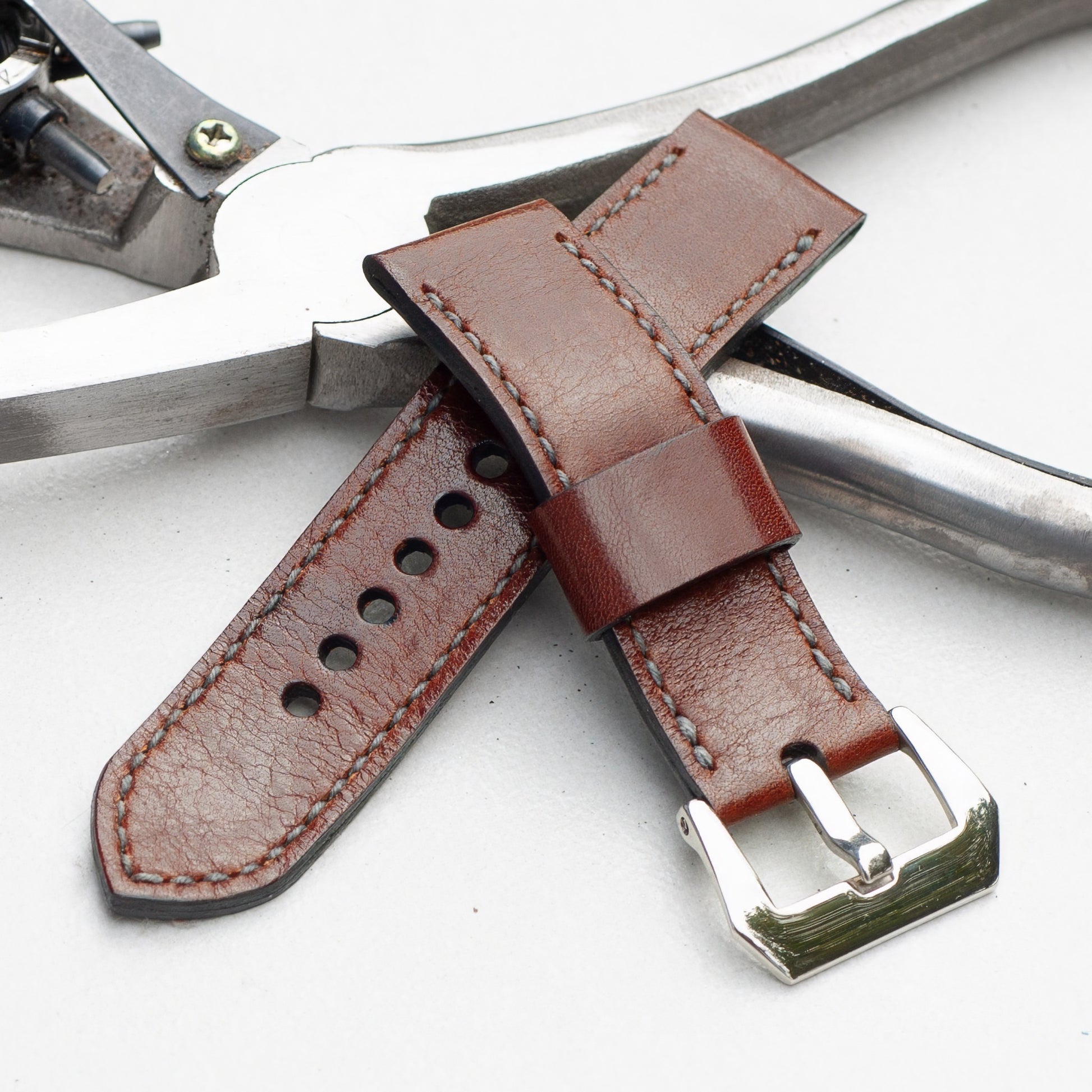 Chestnut leather watch strap with grey stitching and polished steel buckle