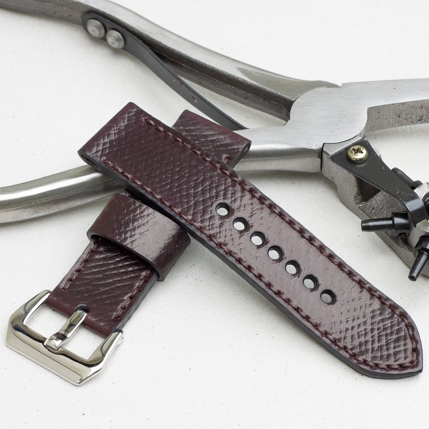 Cognac leather watch strap with dark brown stitching and polished steel buckle