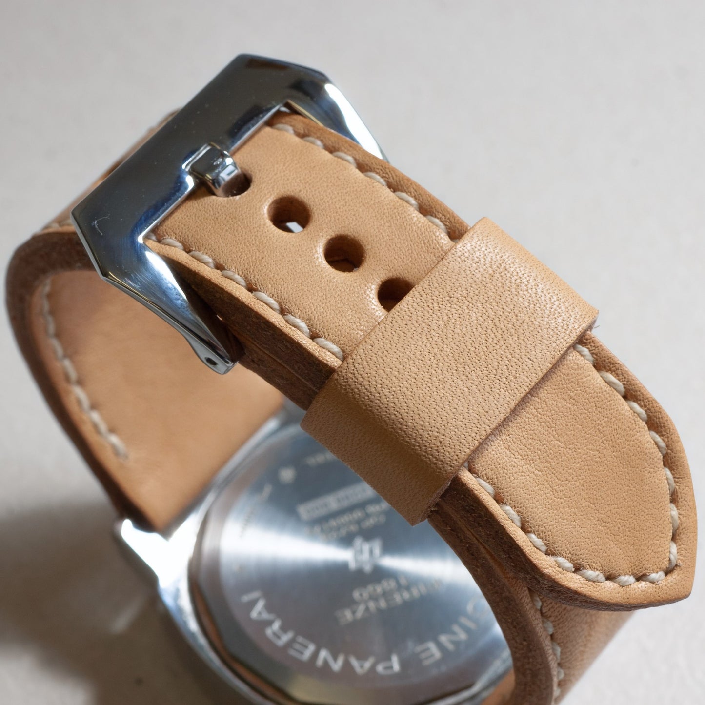 Horween Essex leather watch strap with natural stitching and polished steel buckle