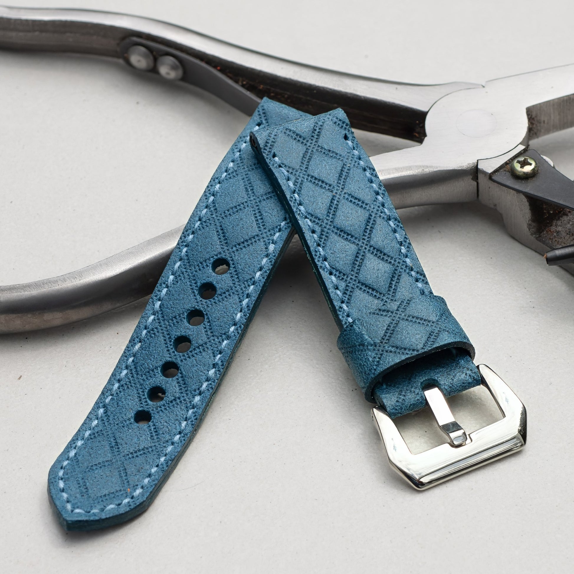 Harlequin leather watch strap with pale  blue stitching and polished steel buckle