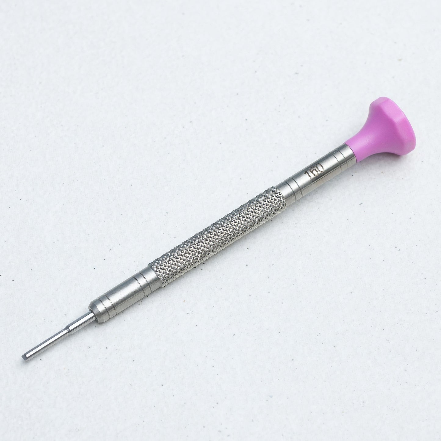 A precision screwdriver with a textured silver metal handle and a bright pink plastic tip, shown on a light gray background.