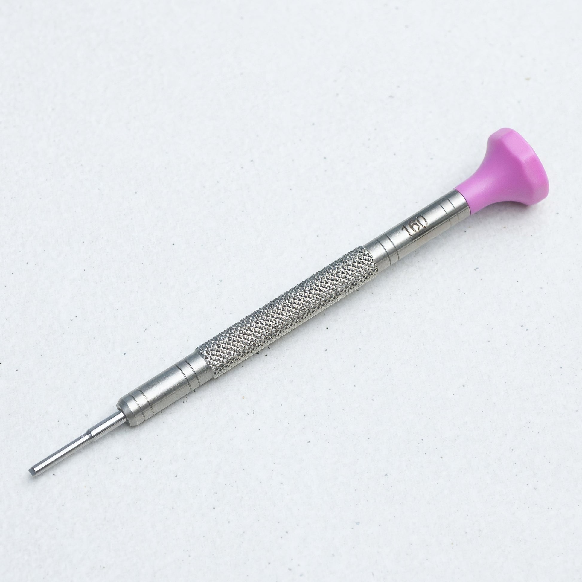 A precision screwdriver with a textured silver metal handle and a bright pink plastic tip, shown on a light gray background.
