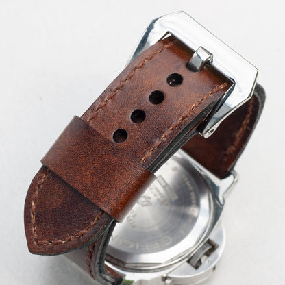 Mahogany leather watch strap with light brown stitching and polished steel buckle