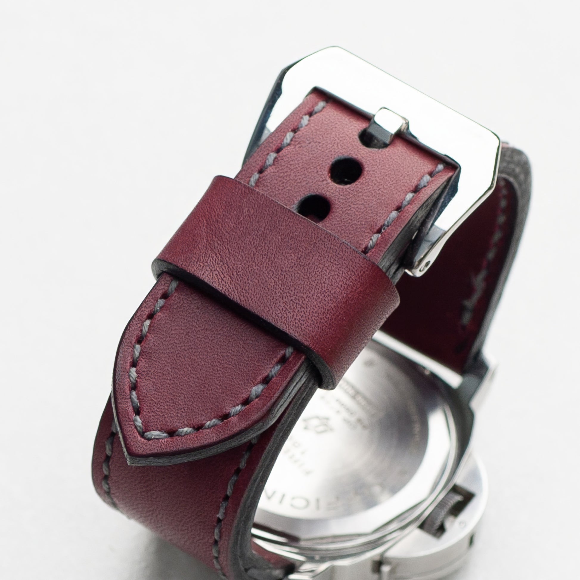 Plum leather watch strap with grey stitching and polished steel buckle