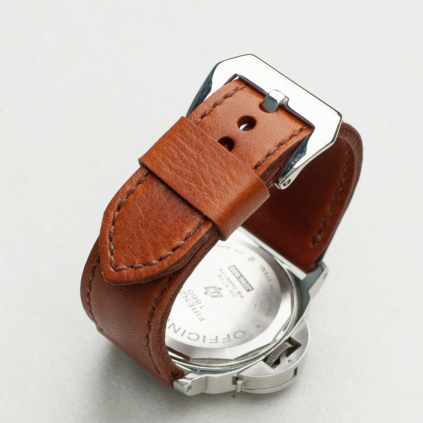 Russet leather watch strap with light brown stitching and polished steel buckle