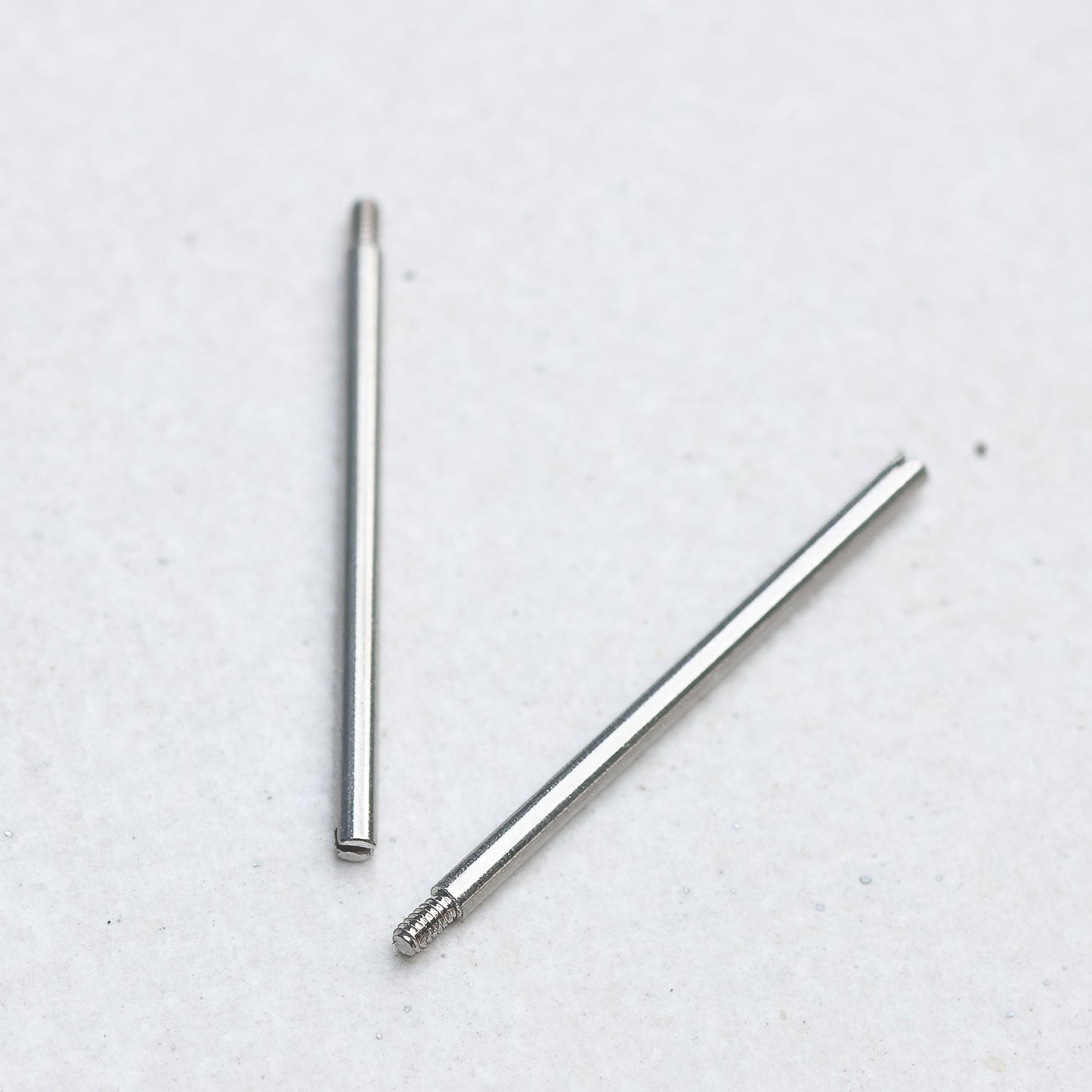 Two Panerai screw bars with threaded ends, placed on a plain light gray background.