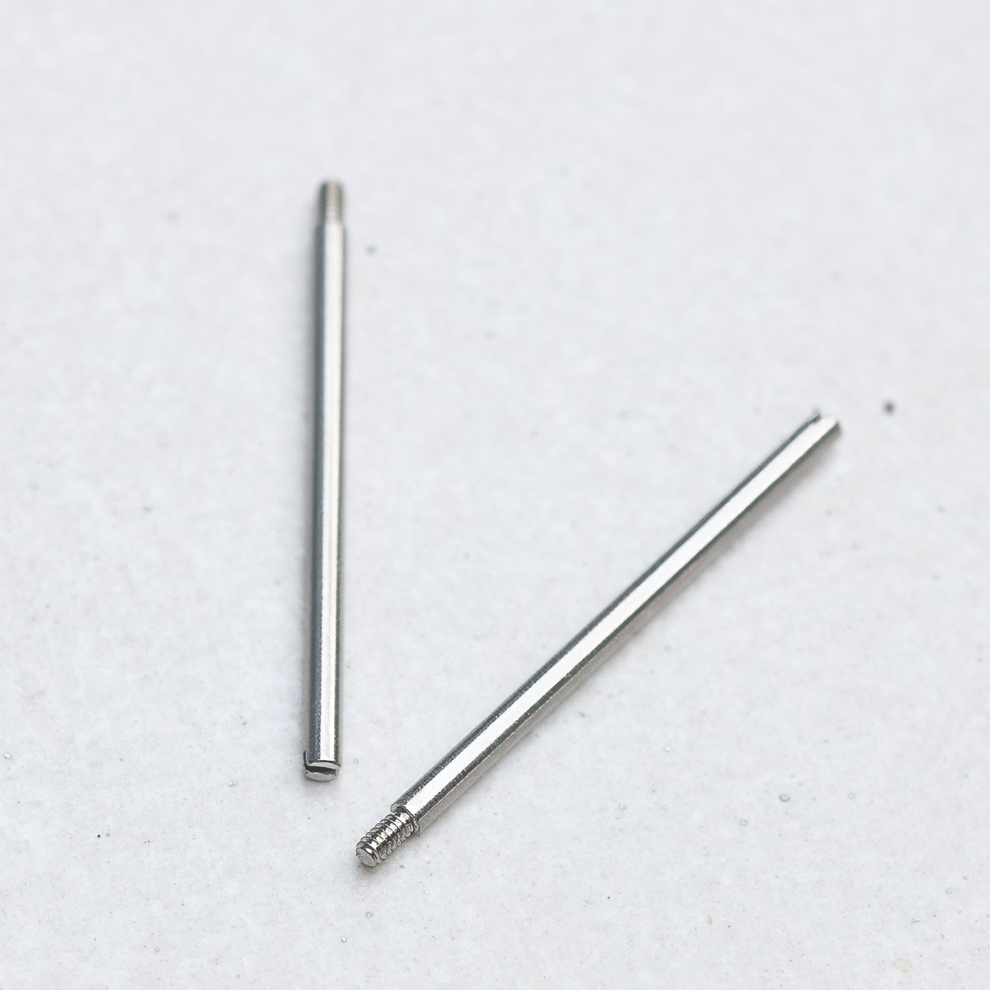Two Panerai screw bars with threaded ends, placed on a plain light gray background.