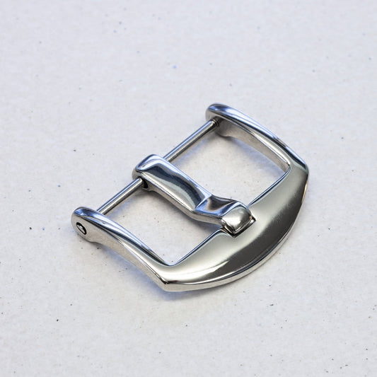 A polished stainless steel watch strap buckle with a curved profile, shown on a light gray textured background.