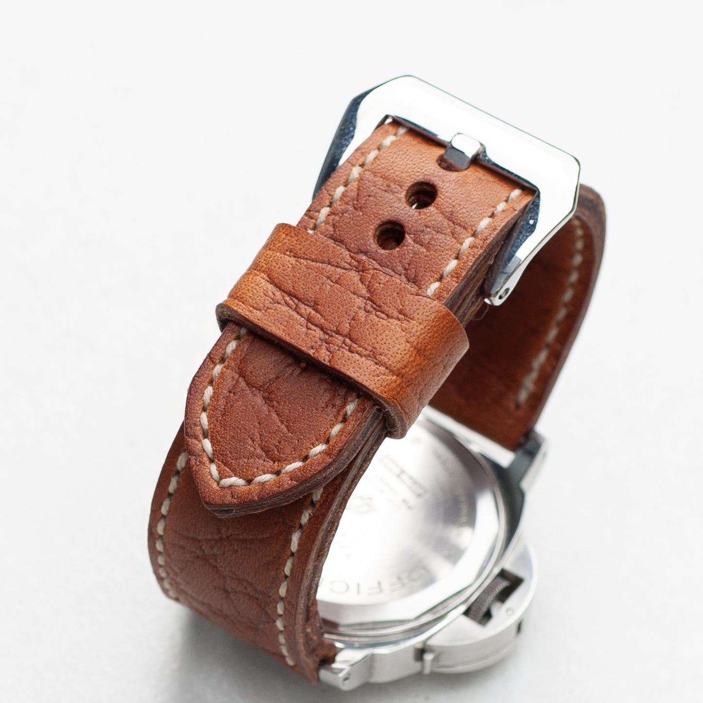 Walnut leather watch strap with natural stitching and polished steel buckle