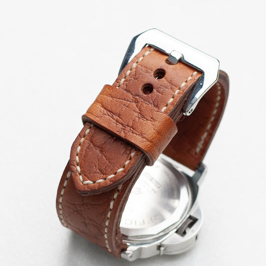 Walnut leather watch strap with natural stitching and polished steel buckle